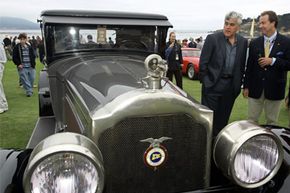 Comedian Jay Leno (second from right), looks over a 1925 Packard 236 on display during the Pebble Beach Concours d'Elegance in Pebble Beach, Calif.