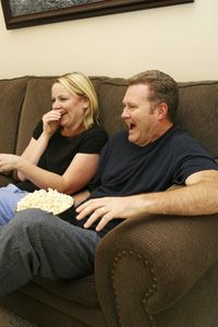 couple laughing at television