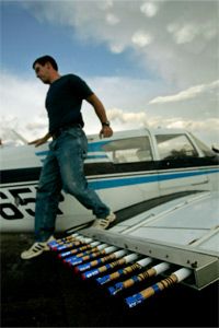 A pilot exits his plane past flares used in cloud seeding after flying a 2007 mission for the Western Kansas Weather Modification program.