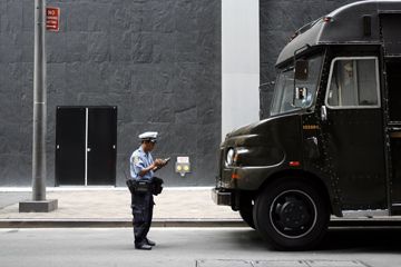 An officer writes a parking ticket for a UPS truck in New York.