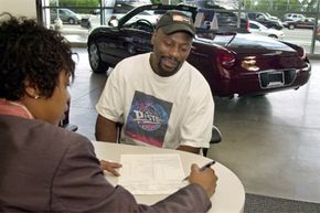 A sales representative explains a leasing contract to a customer at the Bob Maxey Ford dealership in Detroit.