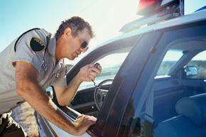 police officer speakin into radio near squad car