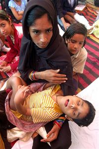In 2007, a Bhopal resident carries her 10-year-old sister born with congenital abnormalities linked to the disaster.