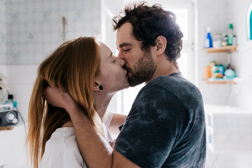 A couple who met through an online dating app romantically engaged in a kiss.