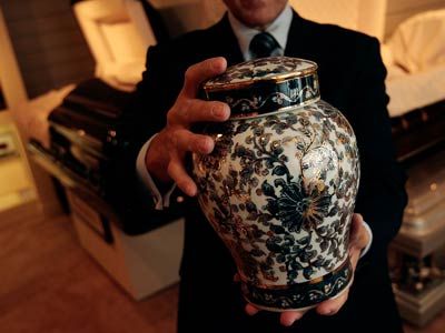 Funeral director Peter DeLuca, owner of Greenwich Village Funeral Home, holds a cremation urn in the showroom of his funeral parlor in New York City