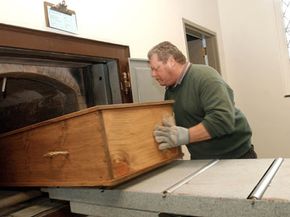 Crematory operator Joe Bancewicz places a coffin into the retort at Mount Auburn Cemetery, Feb. 21, 2002, in Watertown, Mass.