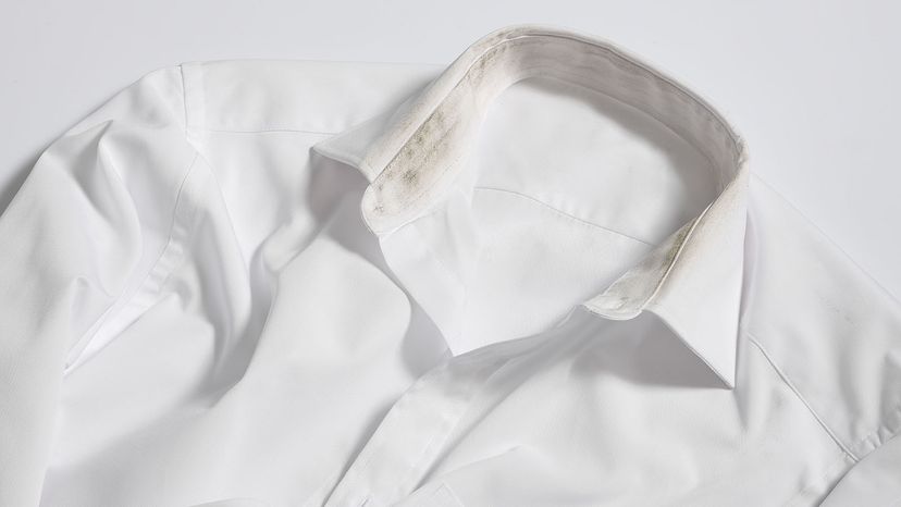 A white dress shirt with yellow and black stains around the inside of the collar.