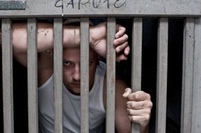 A young man behind bars.