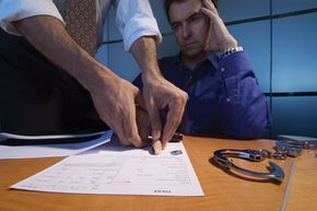 A man is fingerprinted at a police station.