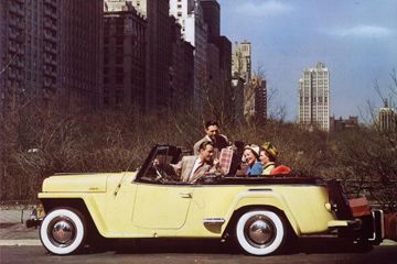 Two couples riding in a yellow Jeepster through Central Park, New York.
