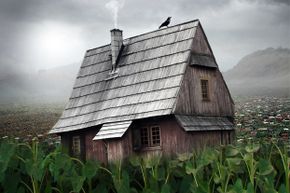 A crow sits on top of an old wooden house.