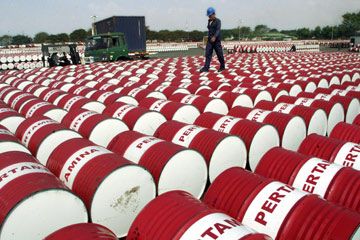 An Indonesian worker walks on barrels of oil at a distribution station of the state-owned oil company Pertamina in Jakarta, Indonesia, on June 24, 2005.
