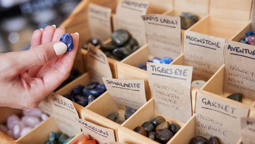 Woman Choosing Healing Crystals In Shop