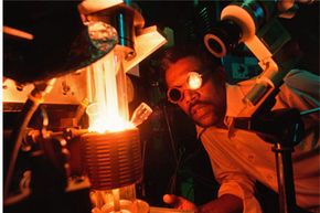 Circa 1975: Senior lab technician Charles Young watches sapphire crystals growing in a crystal grower at the Corning Glass Canada Road plant. The crystals were used in sodium vapor lamps.