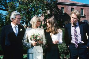 Four wealthy, genteel characters from the TV show 'Dynasty' stand preparing for a wedding.