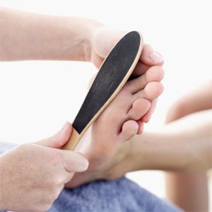 Person filing sole of foot.