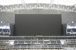 Despite the objections of various coaches and players, the scoreboard in the Dallas Cowboys stadium isn't likely to go dark soon.