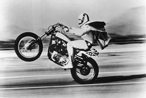 American stunt performer Evel Knieval pulls a 'wheelie' with his motorcycle.