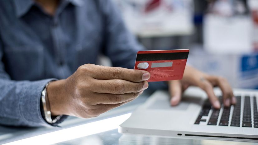 man with credit card on computer