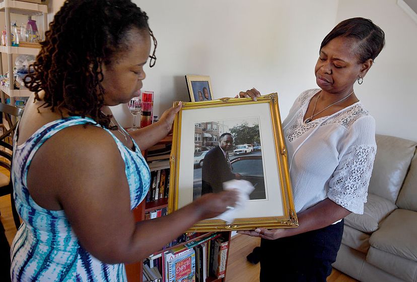 Lawanda Fearrington (left) and her sister Nicole both have familial dilated cardiomyopathy, a heart condition that killed their father in 2003 (shown in the picture they are looking at). Their other two sisters have the same illness. Michael S. Williamson/The Washington Post via Getty Images