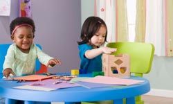Toddlers coloring and playing with blocks at daycare