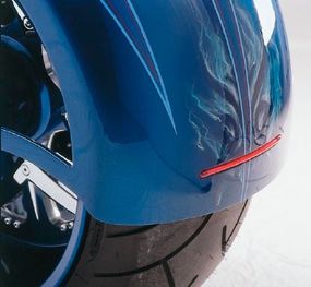 The tires of DD Custom Cycles Pro Street are enveloped by wraparound fenders; the rear one hosts a taillight frenched into its trailing edge.