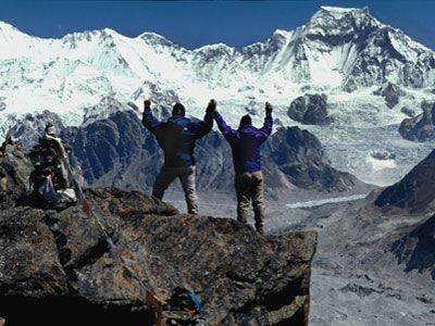 Person climbing mountain peak for outdoor adventure.