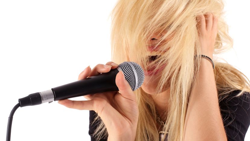Young female musician singing into a microphone.