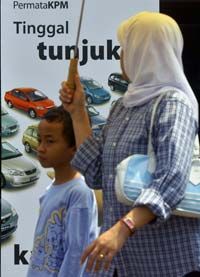 A woman and her son walk past a bank's car loan poster in Jakarta.
