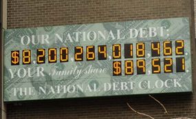 位于纽约曼哈顿中城美洲大道1133号和第44街的国家债务钟显示了截至2006年3月26日的美国政府债务总额(上)和每个美国家庭的计算金额。＂border=
