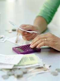 woman's hand with calculator and bills