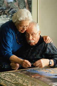 elderly couple works a jigsaw puzzle