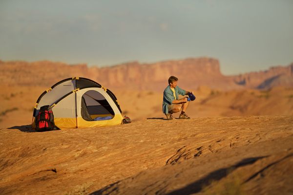 Men adventuring outdoors in nature, tent in tow.