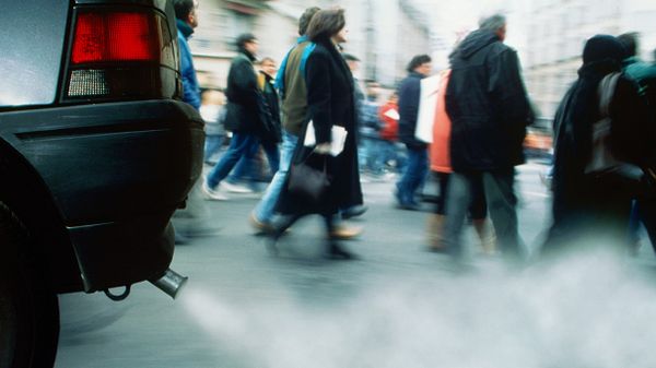 car exhaust fumes with people walking in background