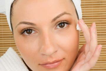 Woman applying moisturizer near eye
