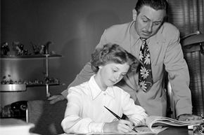Walt Disney watches as Kathryn Beaumont signs a contract.