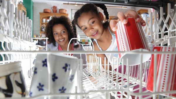 mother and daughter stacking dishwasher