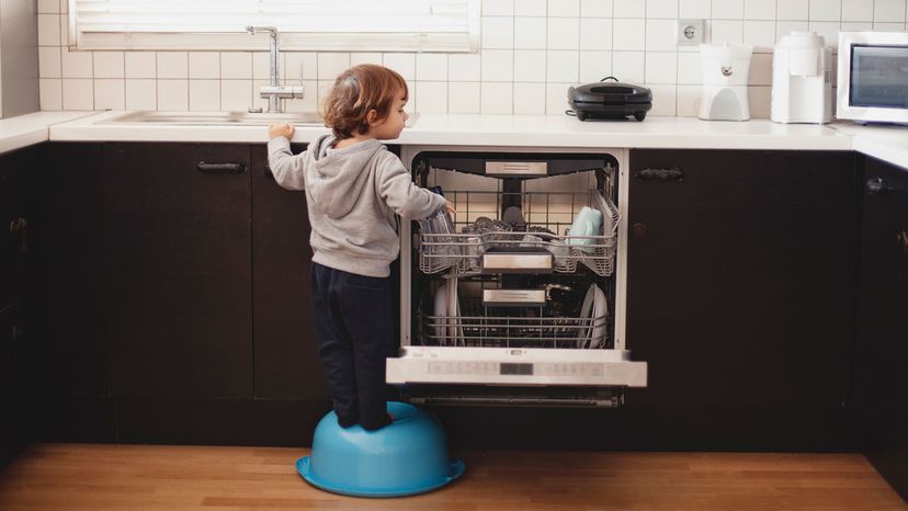 child stacking dishwasher