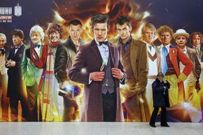 A security guard walks past a giant Doctor Who poster at the 'Doctor Who 50th Celebration' event in London, England.