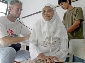 A doctor from Doctors Without Borders performs a checkup in Indonesia.