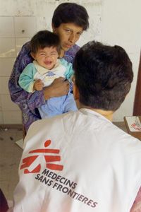 A doctor examining a baby in Kosovo.