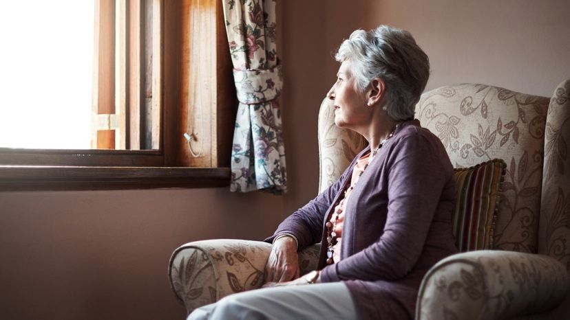 Old lady alone looking at the window