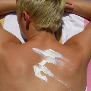 Sunscreen on the back of young man.