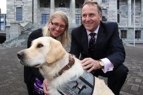 Epilepsy assist dog Roxy and her owner Kate Hendra pose with New Zealand Prime Minister John Key in October 2012.