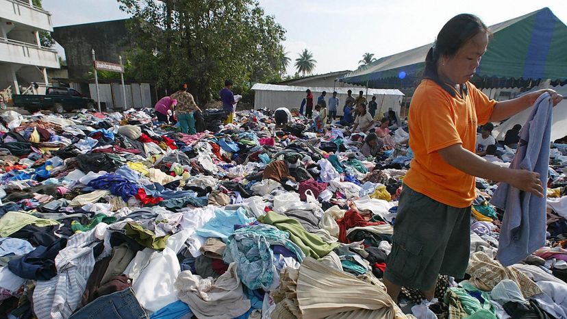 泰国，一位妇女在看捐赠的衣服＂border=