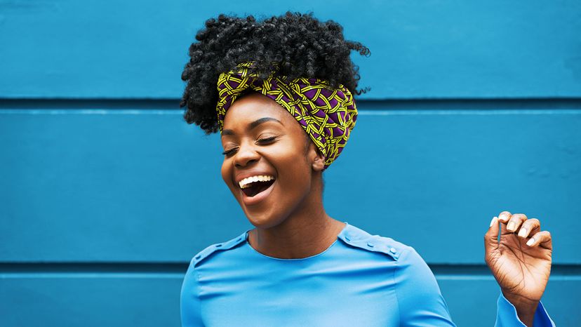 happy black woman on blue wall