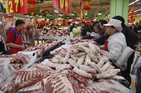Shoppers in China buy pork for the lunar New Year's Eve dinner.  As developing countries join the ranks of frequent meat eaters, the meat supply will become even more strained.