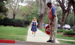 Crossing guard waiting for young student