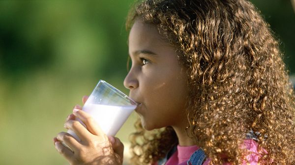 young girl drinking a glass of milk