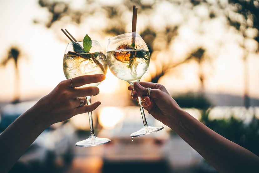 Girlfriends clink cocktails during dinner.